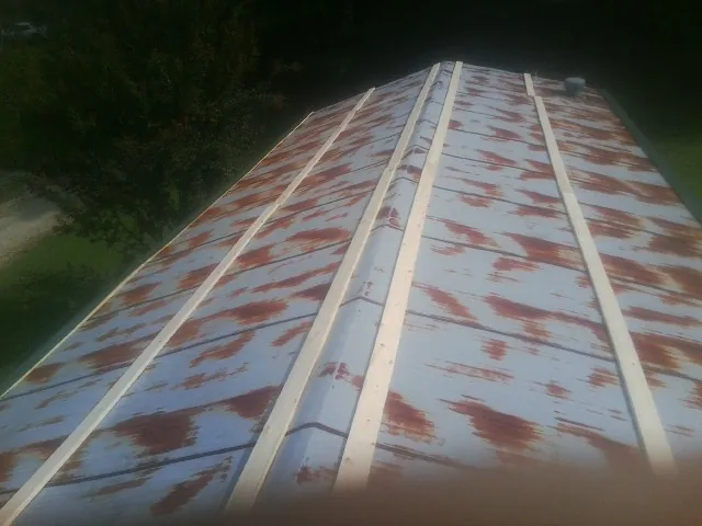 Rusted metal roof panels with new wood purlins before replacement — Storm Damage Roof Repair in Joice by Roofing Brothers
